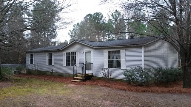 a view of a house with a yard and large tree