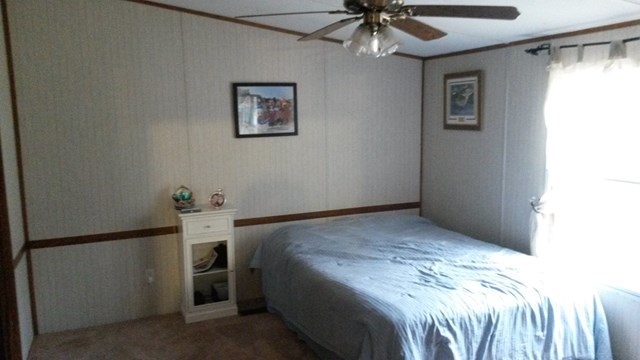 177 Cyler Road Gray, GA 31032 - Photo 10 of 15 a bedroom with a bed and a chandelier