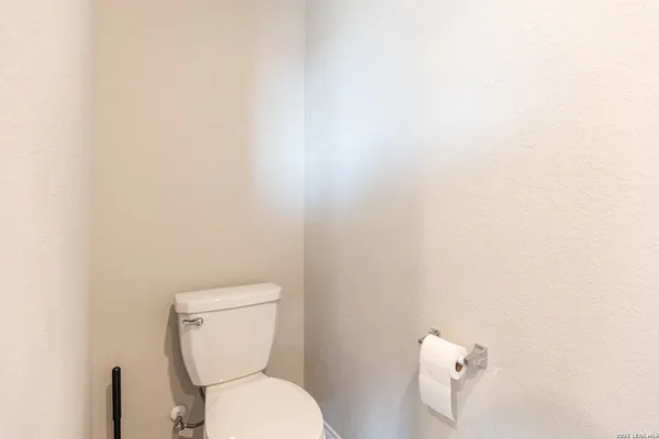 a white toilet sitting next to a white wall