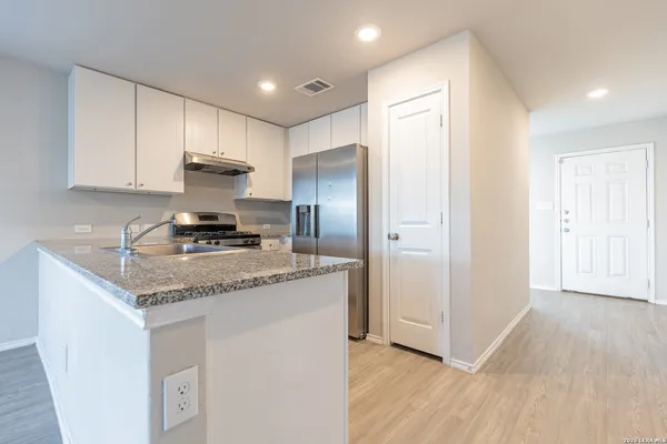 a kitchen with stainless steel appliances granite countertop a refrigerator sink and cabinets