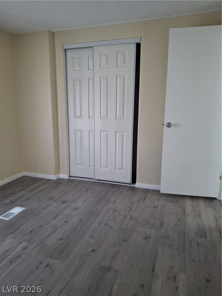 4550 Horn Road Pahrump, NV 89048 - Photo 7 of 12 This interior hallway features wood-look flooring and bi-fold closet doors, offering functional appeal.