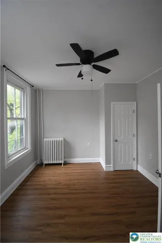 a view of empty room with wooden floor