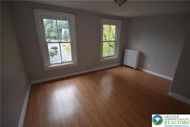 a view of a room with wooden floor and windows