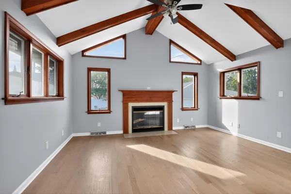 a view of an empty room with a fireplace and a window