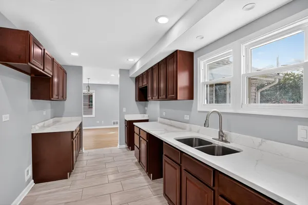 a kitchen with stainless steel appliances granite countertop a sink counter space cabinets and a large window