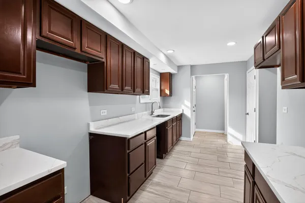a kitchen with a sink refrigerator and cabinets