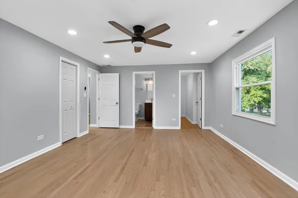 a view of empty room with wooden floor and window