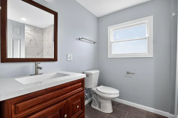a bathroom with a toilet a sink and mirror