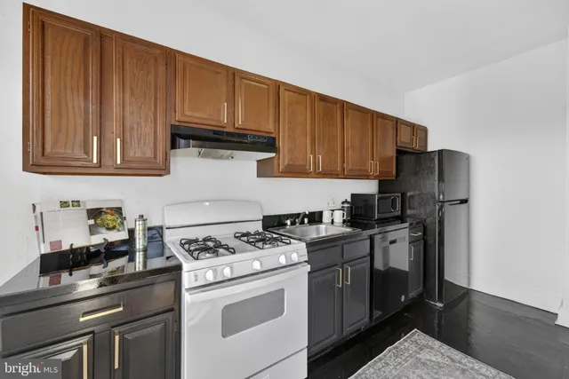 a kitchen with stainless steel appliances granite countertop a stove a refrigerator and a cabinets