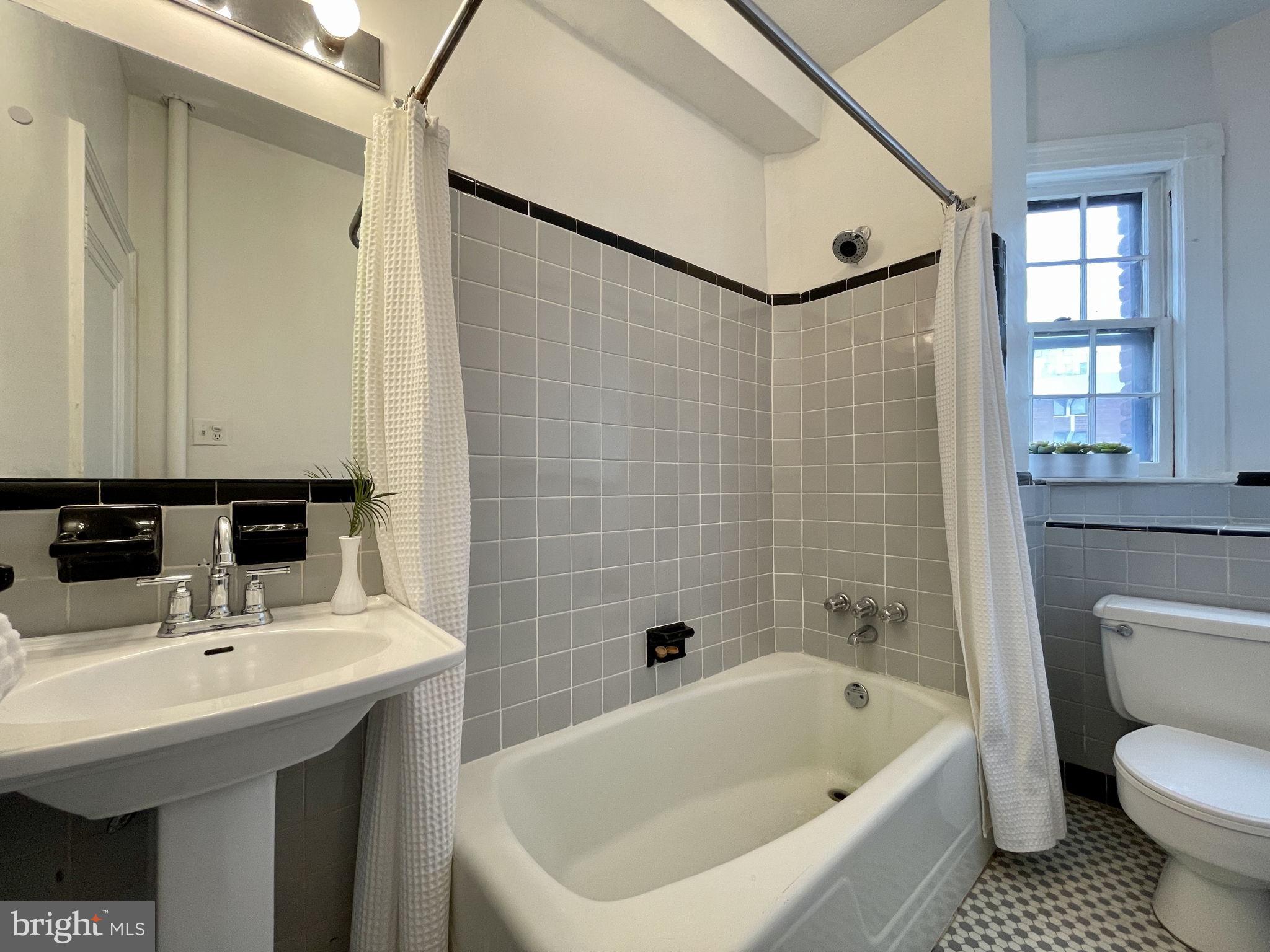 644 Massachusetts Avenue Northeast, Unit 406 Washington, DC 20002 - Photo 19 of 31 a bathroom with a sink a toilet and shower