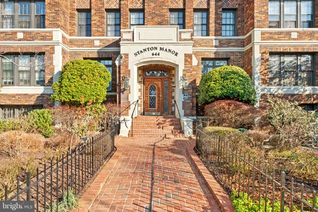 a view of a brick house with large windows