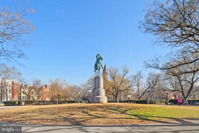 a vase of flowers sitting on a sidewalk