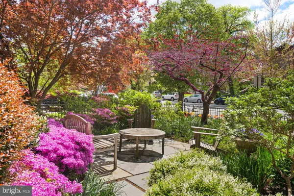 a patio with table and chairs and potted plants