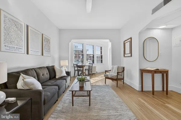 a living room with furniture a rug a lamp and a window