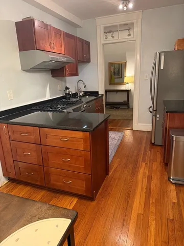 a kitchen with granite countertop wooden cabinets and a stainless steel appliances