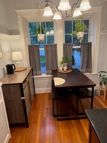 a kitchen with a sink a refrigerator a microwave a dining table and chairs