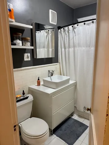a bathroom with a sink a toilet and shower curtain