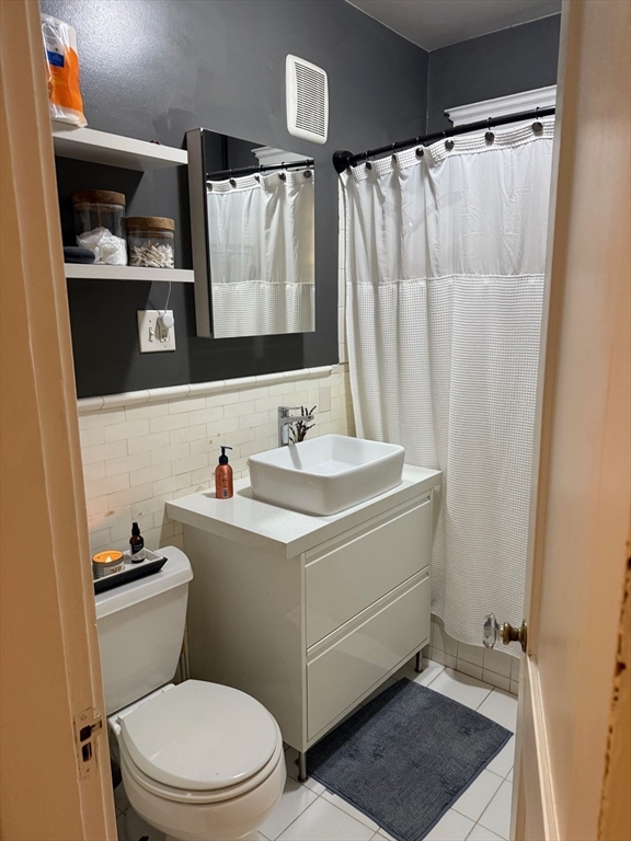 11 Vinal Street, Unit 3 Boston, MA 02135 - Photo 7 of 10 a bathroom with a sink a toilet and shower curtain