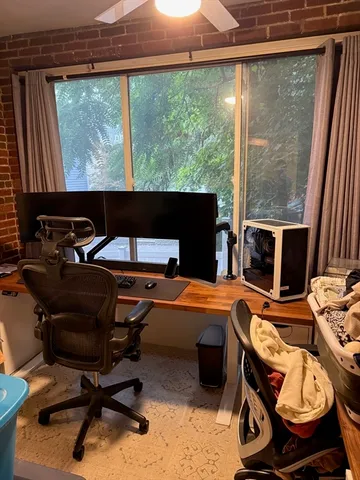 a view of a workspace with furniture and a window