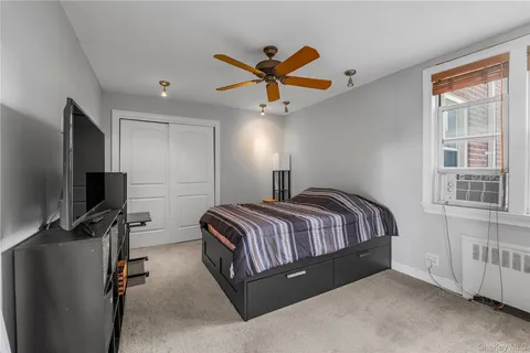a spacious bedroom with a bed and a flat screen tv