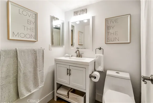 a bathroom with a sink mirror and toilet