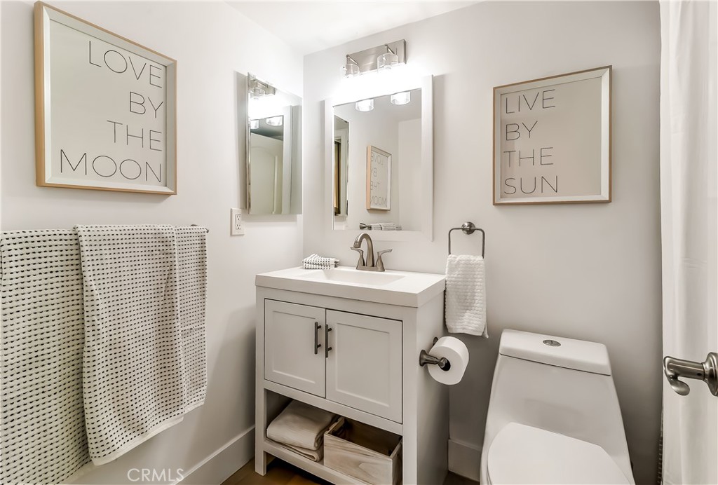 33852 Del Obispo Street, Unit 2 Dana Point, CA 92629 - Photo 12 of 30 a bathroom with a sink mirror and toilet