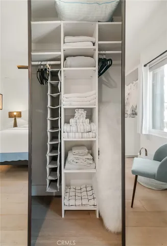 a view of walk in closet with clothes and shoes