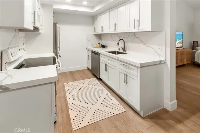 a kitchen with a sink a stove and cabinets