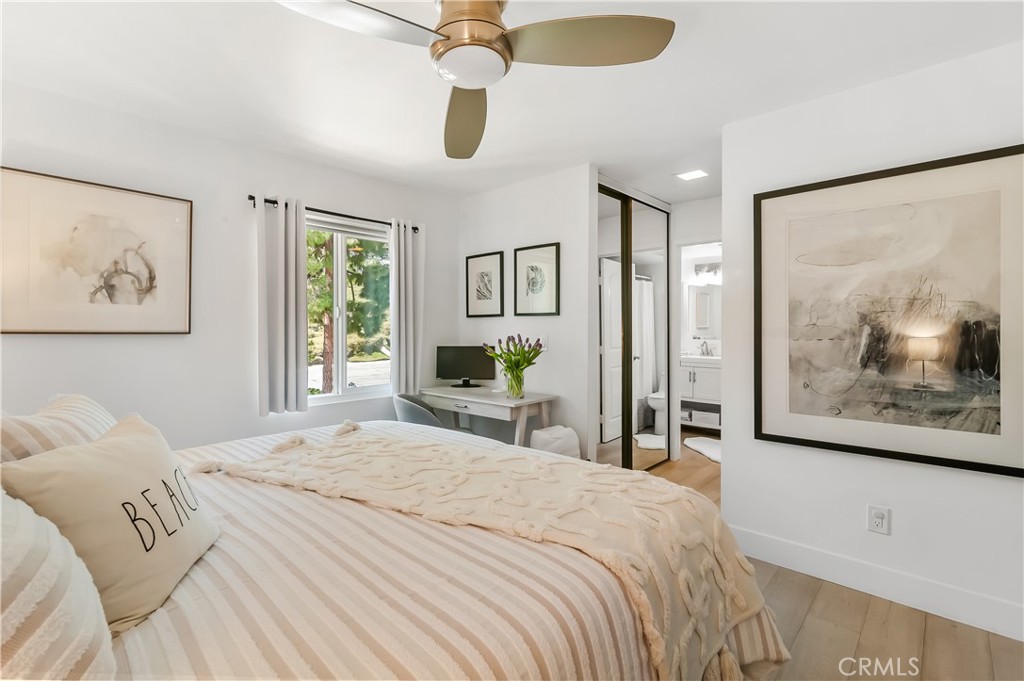 33852 Del Obispo Street, Unit 2 Dana Point, CA 92629 - Photo 9 of 30 a bedroom with a large bed and a chandelier