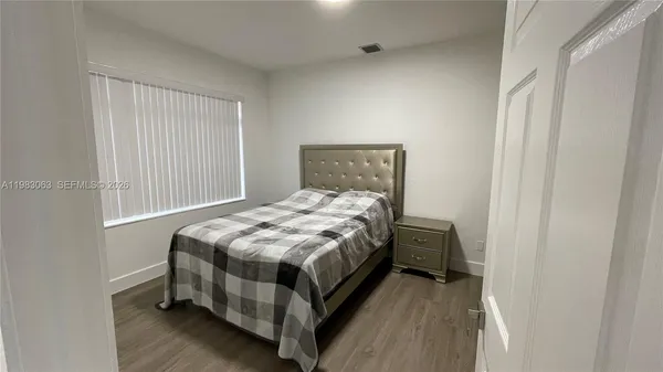 a bedroom with a bed and wooden floor