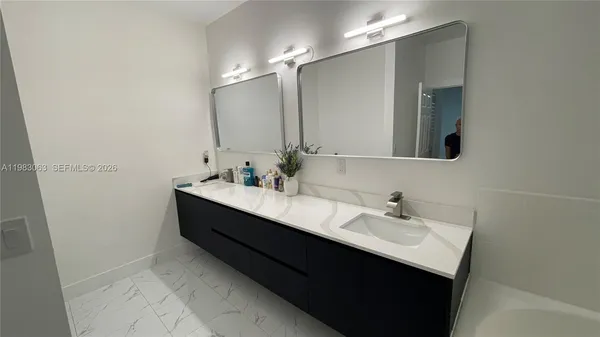 a bathroom with a sink vanity and mirror