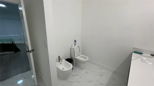 a white toilet sitting next to a shower