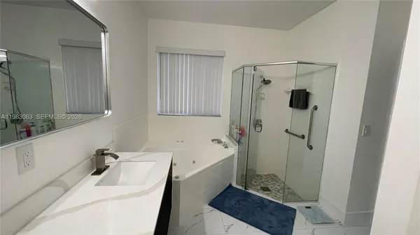 a bathroom with a sink a mirror and a shower