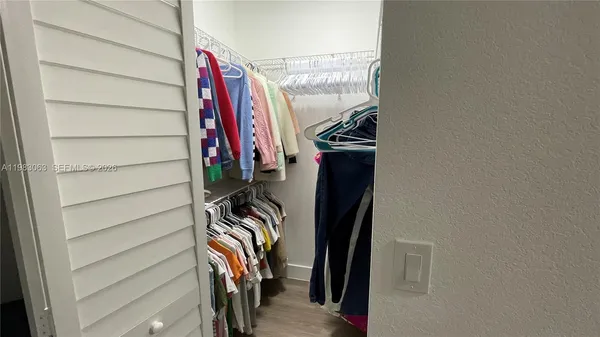 a view of walk in closet with clothes