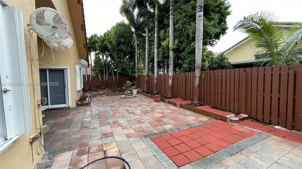 a view of backyard with potted plants and palm trees