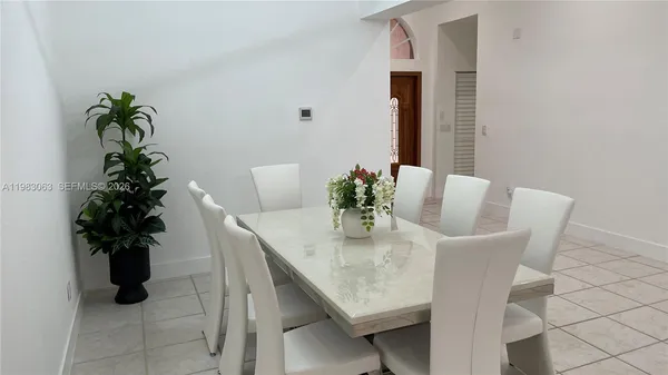 a dining room with furniture and potted plants