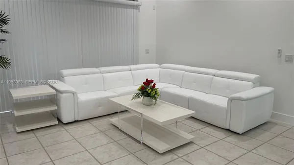 a living room with furniture and a potted plant