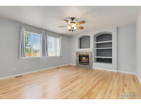 a view of an empty room with a fireplace and a window