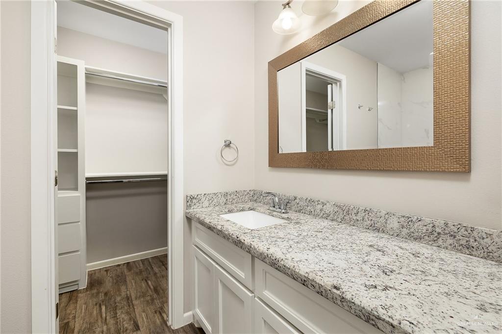 1305 Alta Vista Drive, Unit 4 Weslaco, TX 78596 - Photo 11 of 13 Bathroom featuring a walk in closet, vanity, and dark wood finished floors