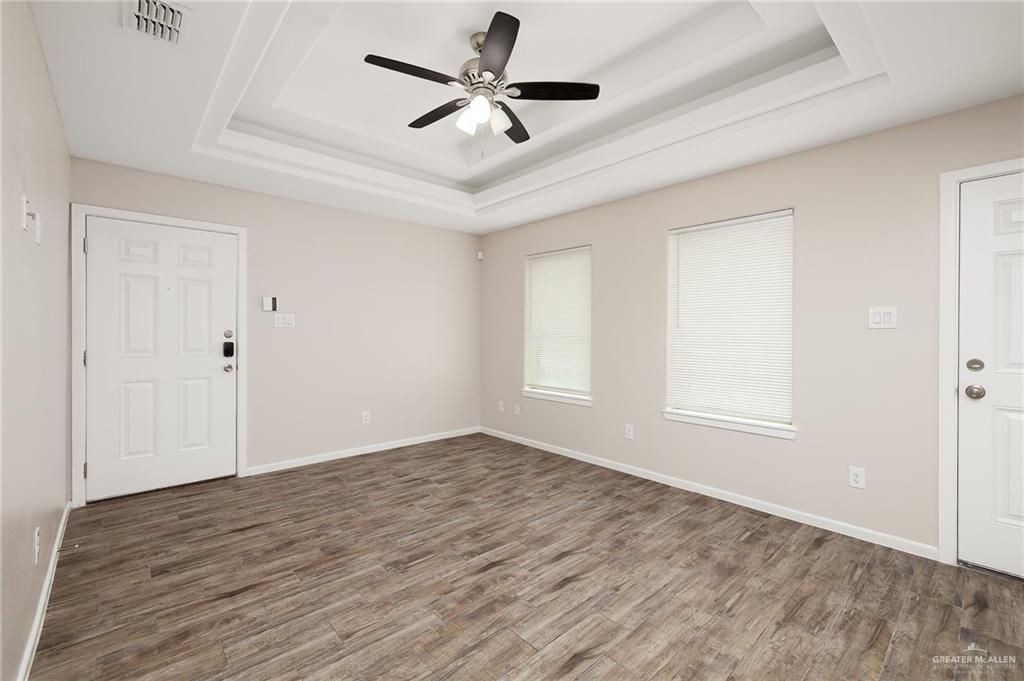 1305 Alta Vista Drive, Unit 4 Weslaco, TX 78596 - Photo 3 of 13 Spare room with dark wood-type flooring, a tray ceiling, and ceiling fan
