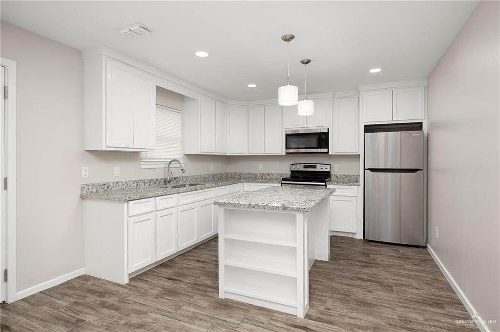1305 Alta Vista Drive, Unit 4 Weslaco, TX 78596 - Photo 5 of 13 Kitchen with open shelves, stainless steel appliances, pendant lighting, white cabinetry, and recessed lighting