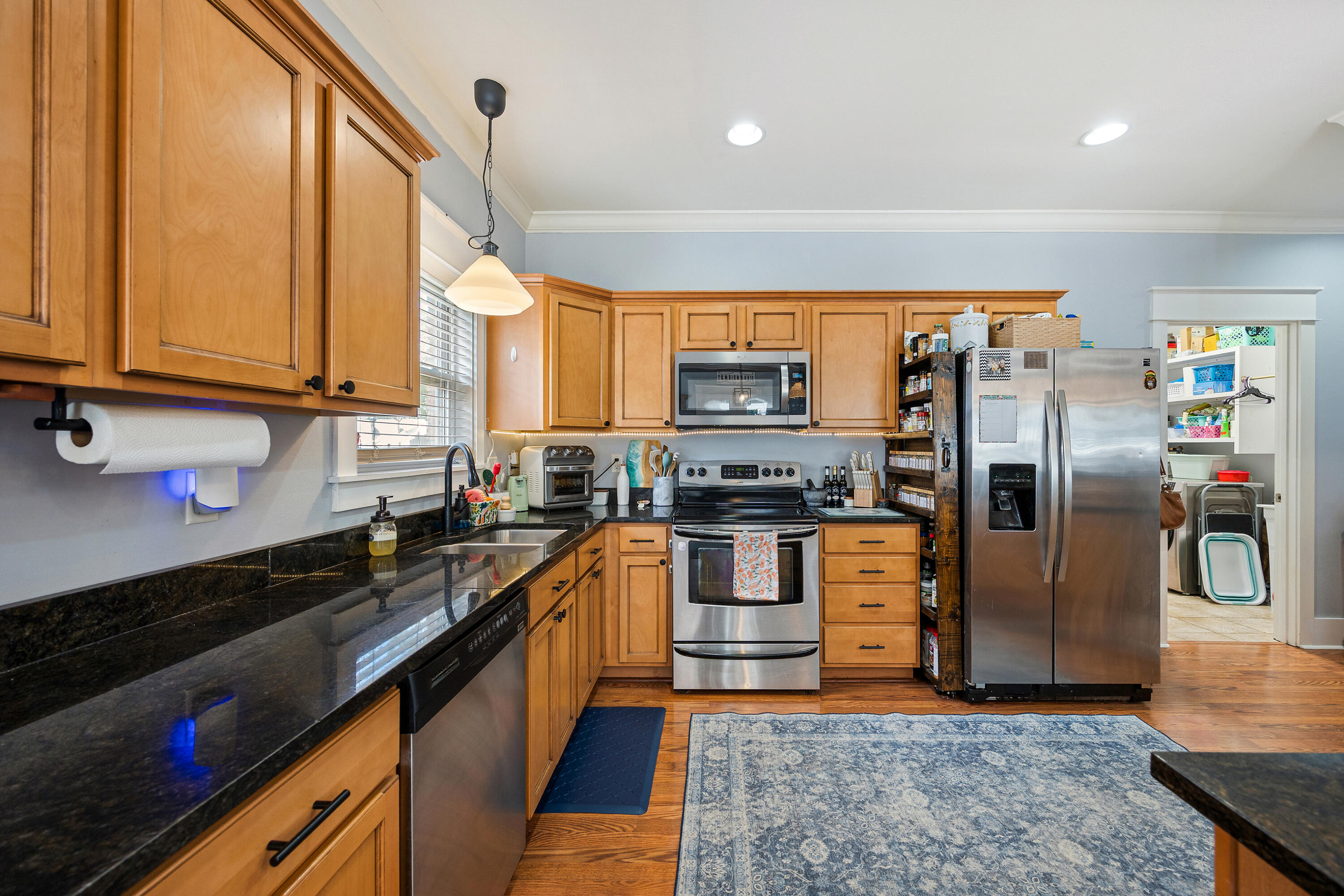 804 Symphony Way Freeport, FL 32439 - Photo 12 of 34 a kitchen with stainless steel appliances granite countertop a refrigerator a stove and a sink with wooden floor