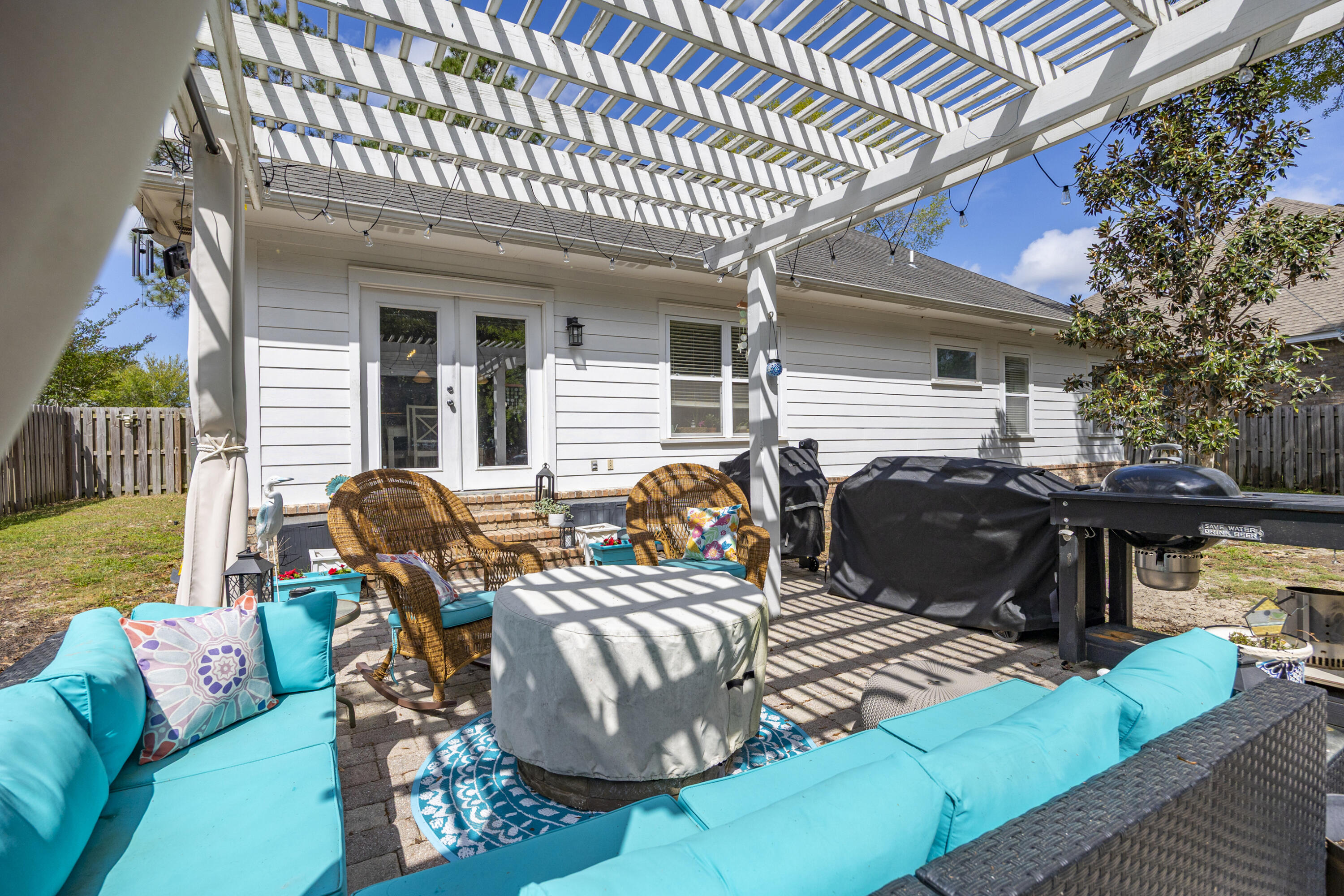 804 Symphony Way Freeport, FL 32439 - Photo 26 of 34 a view of a patio with table and chairs with wooden floor and fence