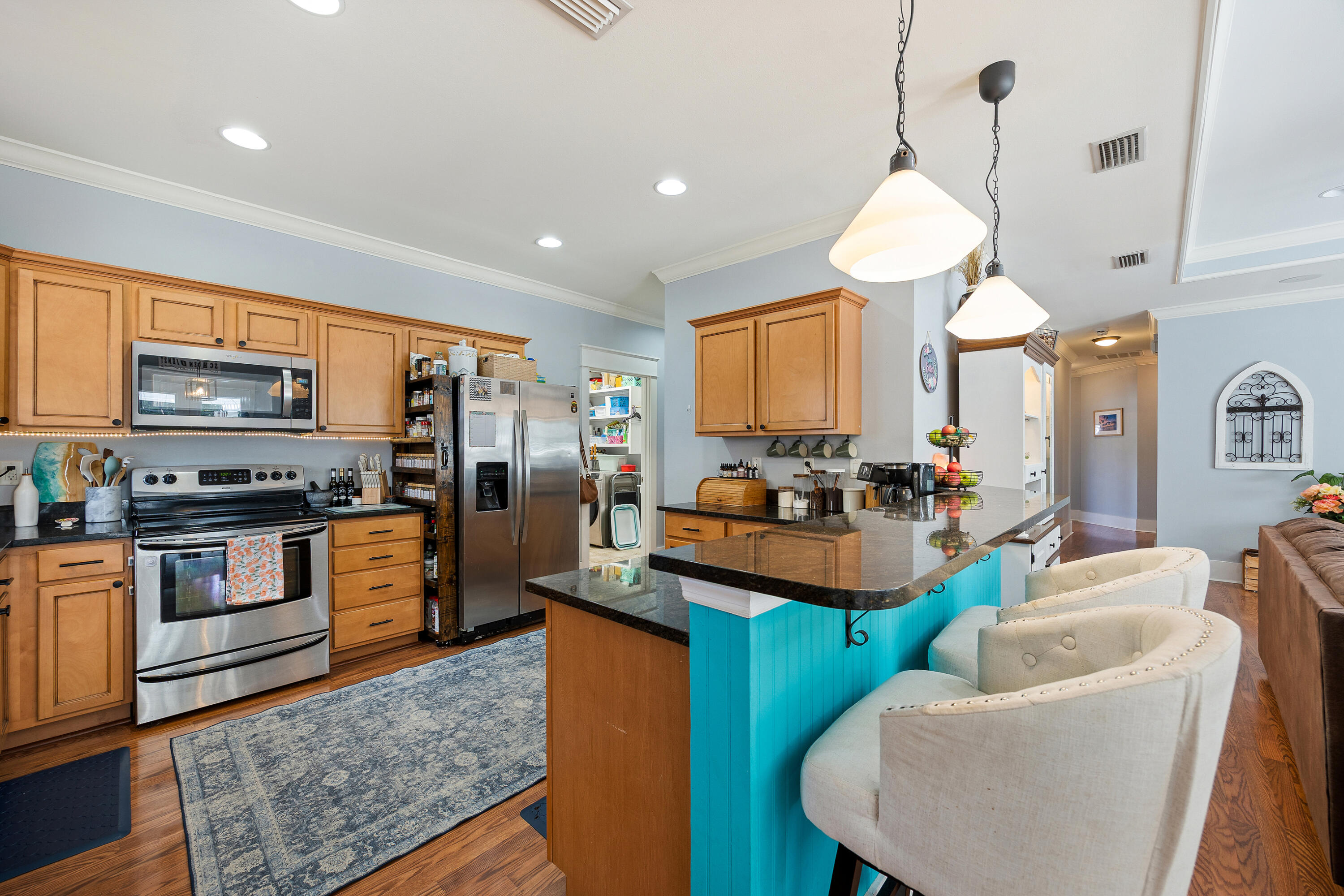 804 Symphony Way Freeport, FL 32439 - Photo 8 of 34 a kitchen with stainless steel appliances kitchen island granite countertop a sink dishwasher a microwave oven a stove and a refrigerator with wooden floor