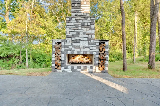 a view of a brick wall with two windows and a yard