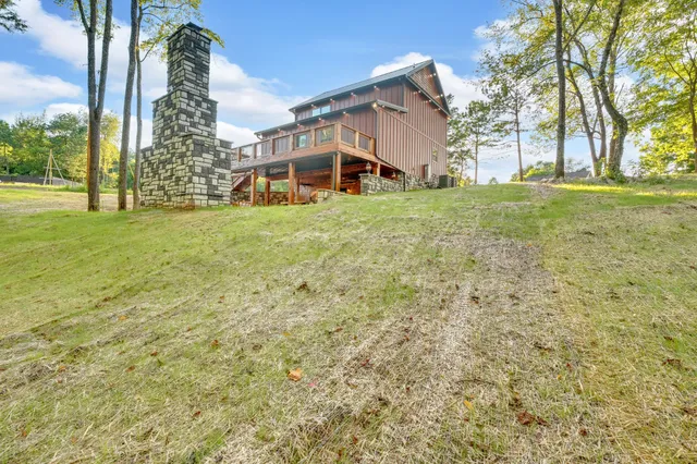 a view of a house with a big yard and large trees