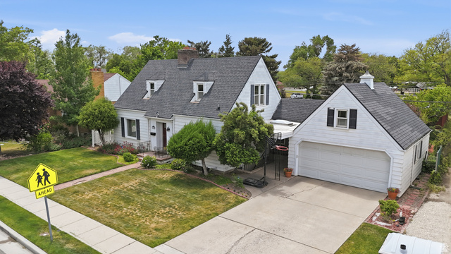7576 South Jefferson Street Midvale, UT 84047 - Photo 47 of 53 Traditional Cape Cod style residence featuring white siding, a dark shingled roof, and multiple dormer windows