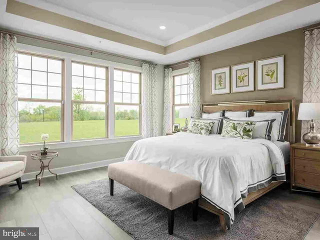 a bedroom with a bed and large windows