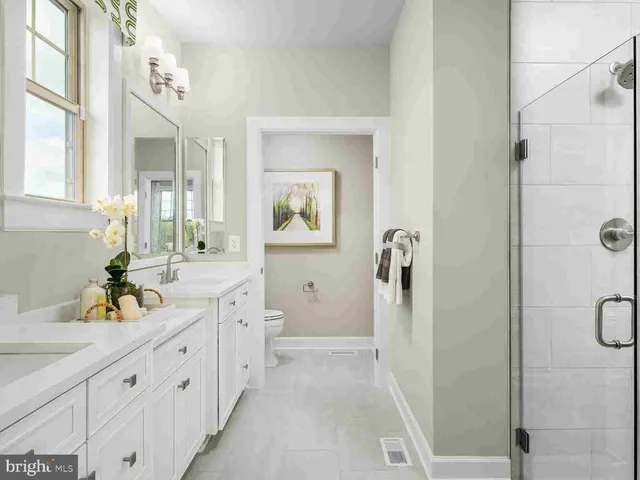 a spacious bathroom with a double vanity sink a mirror a shower and a bathtub