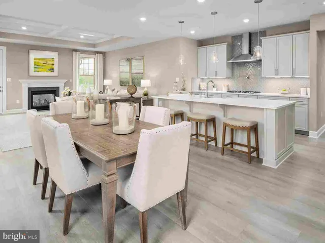 a dining room with kitchen island furniture a wooden floor and a fireplace